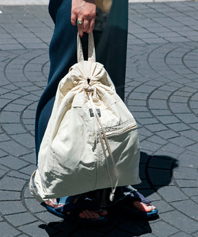 ナップサックを持った女性の足元