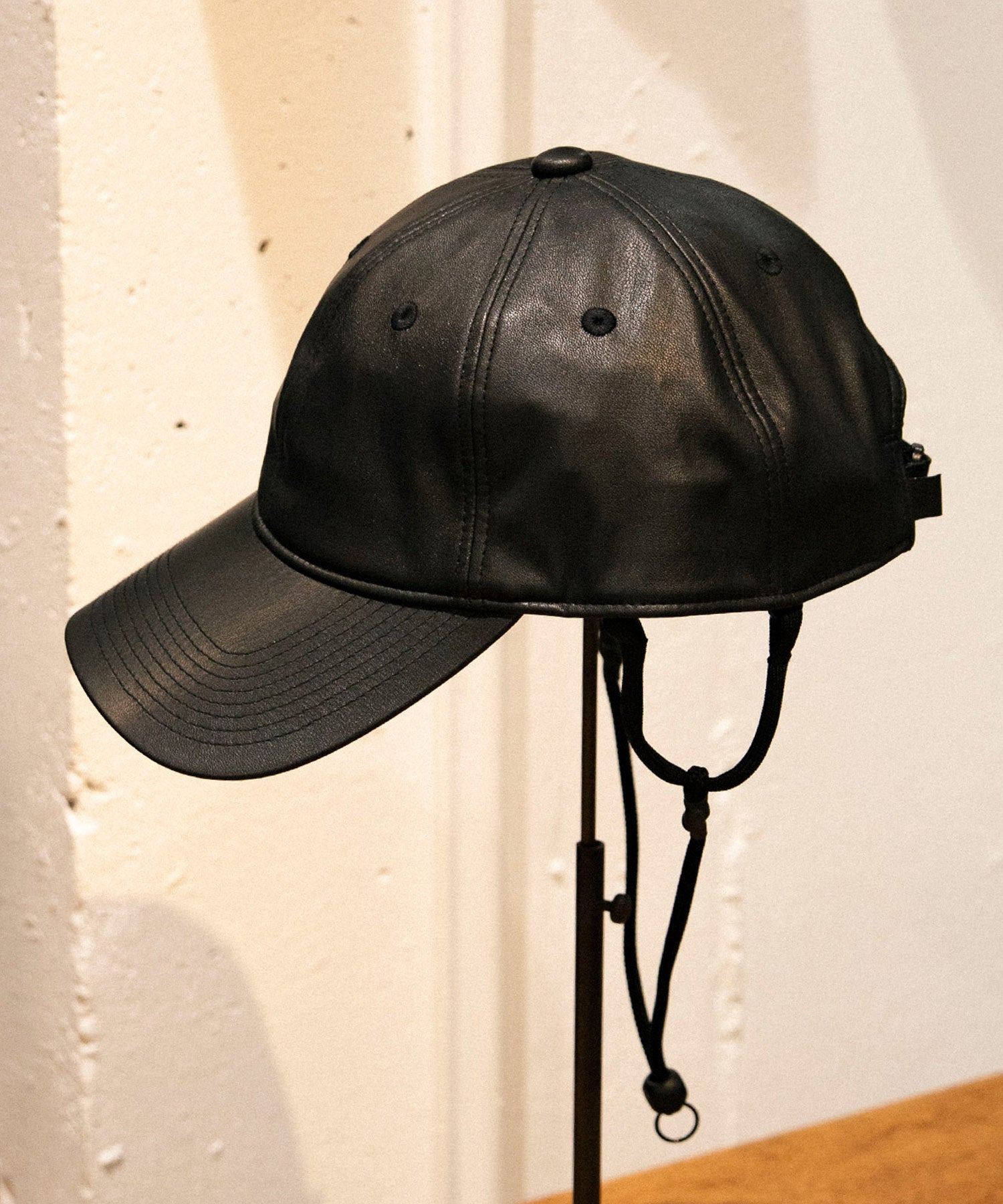 黒いフェイクレザーのキャップ