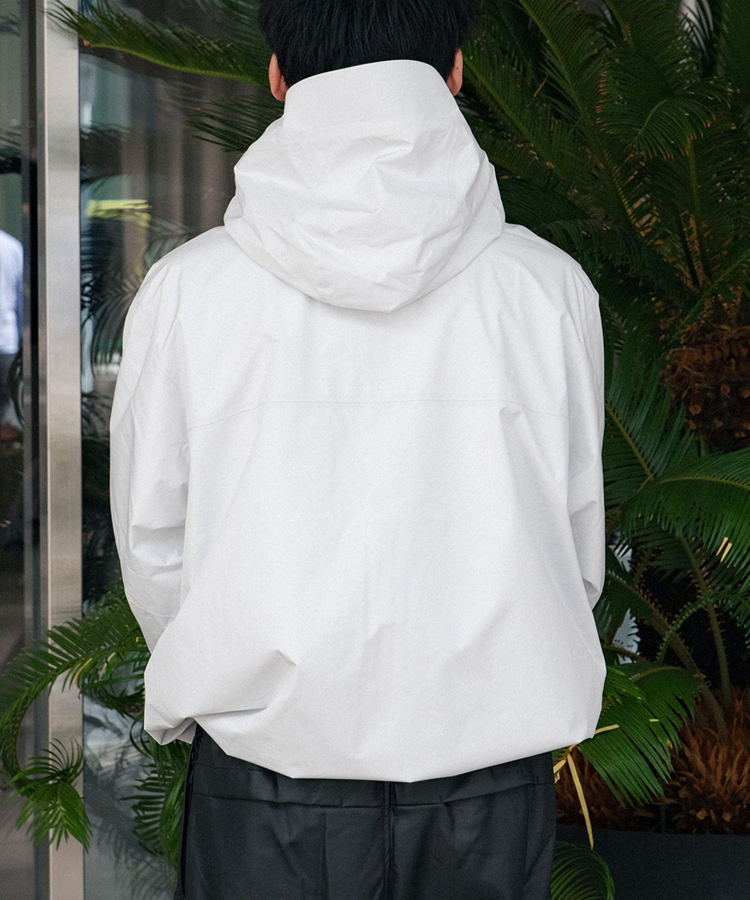 ホワイトのシェルジャケットを着た男性