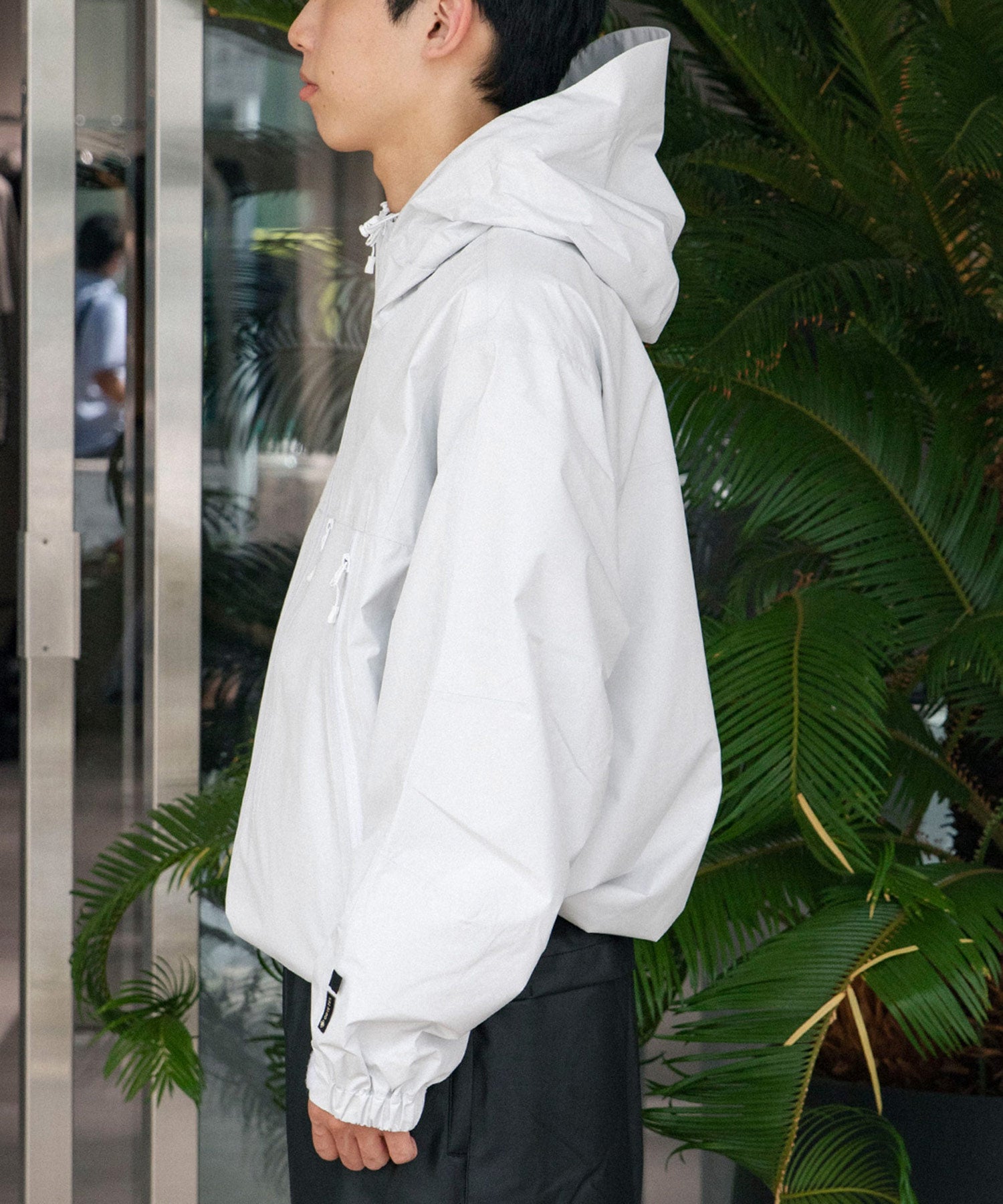 ホワイトのシェルジャケットを着た男性