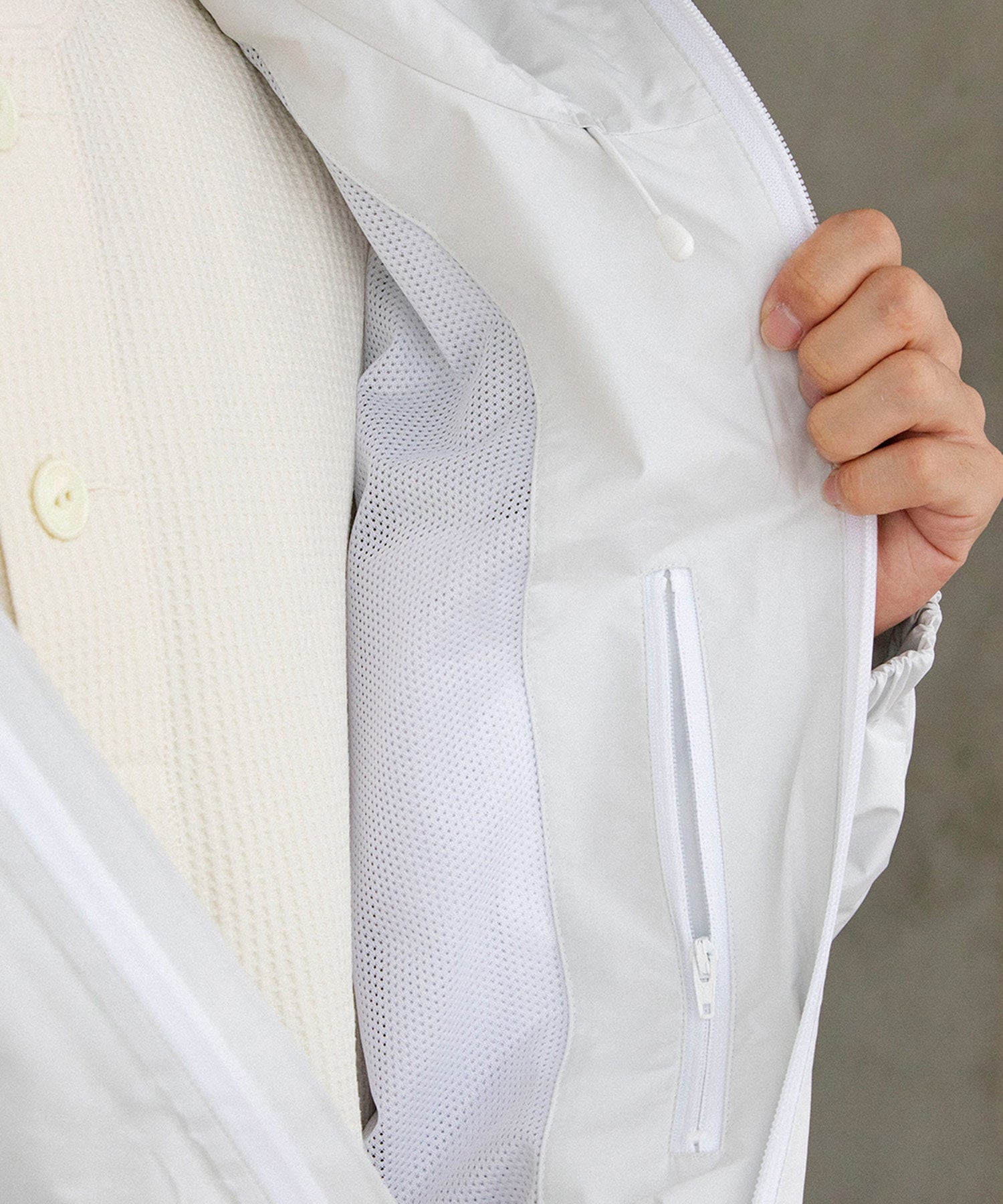 ホワイトのシェルジャケットを着た男性